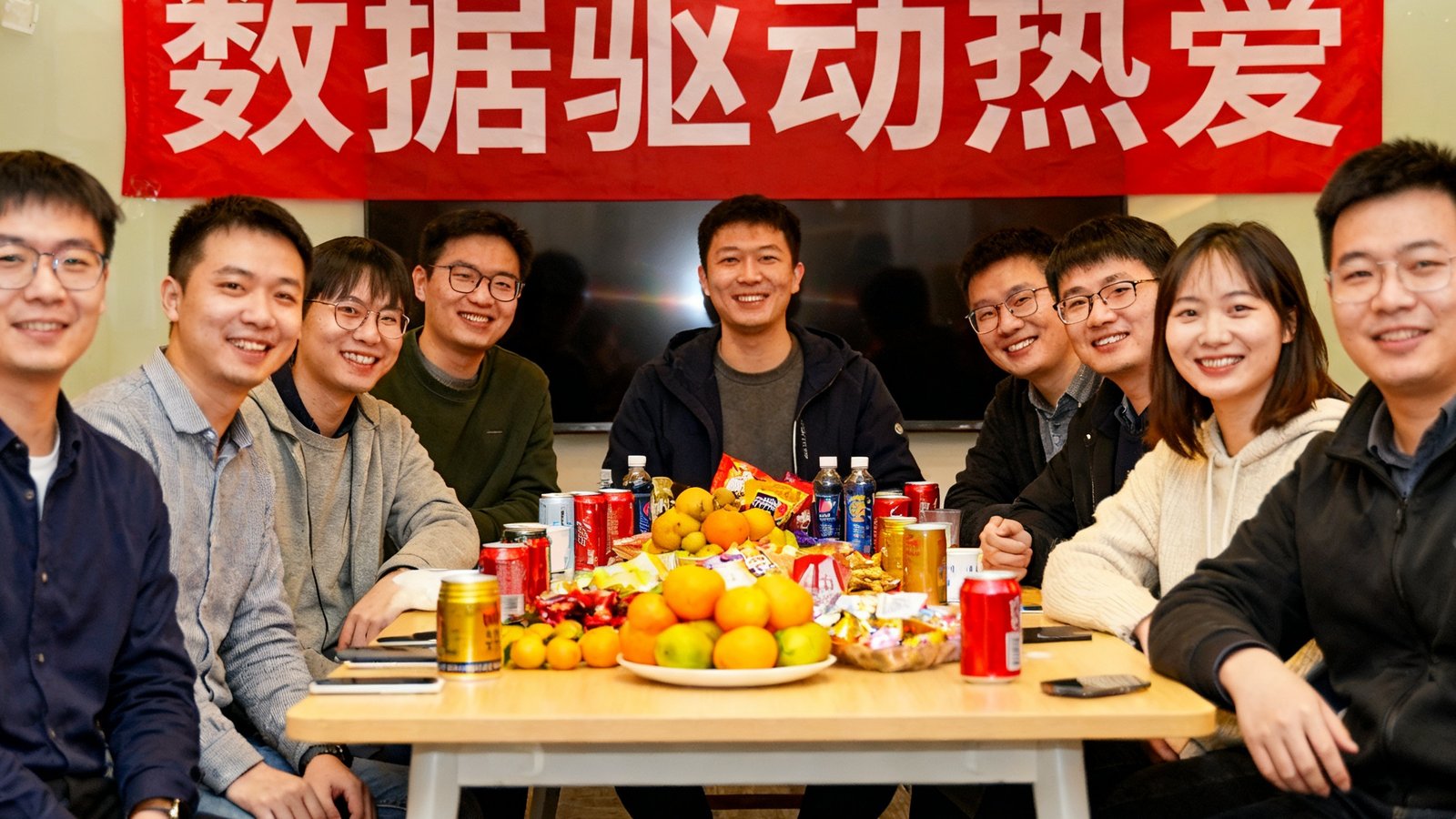 看球网技术团队在2025年新年聚会，横幅写着'数据驱动热爱'